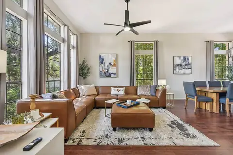 Elegant, comfy front Living Room with generous seating on the large leather couch surrounded by views of nature