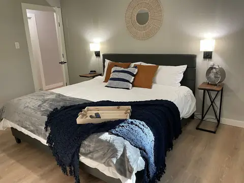 Ahhhh, your plush King bed w/mattress & pillow protectors, Side tables are perfect to swing around to use your laptop in bed, dimmable wall lamps have plugs…