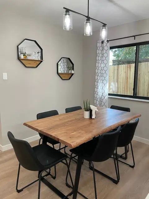 Modern Live-Edge custom dining table with seating for 6, dimmable lighting for ambiance, with additional seating at the waterfall bar top overlooking pecan…